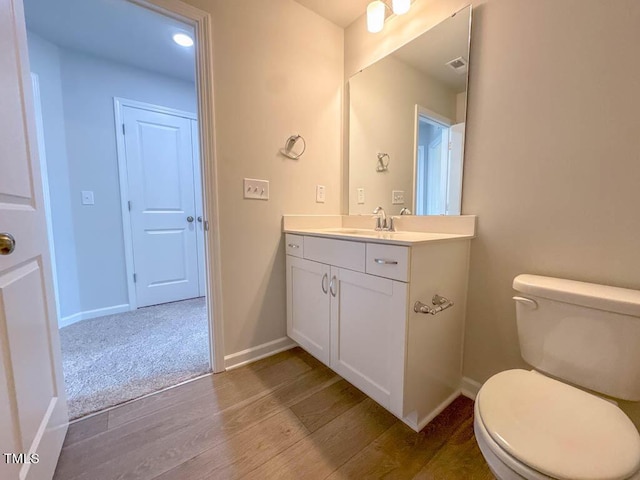 bathroom featuring hardwood / wood-style floors, vanity, and toilet