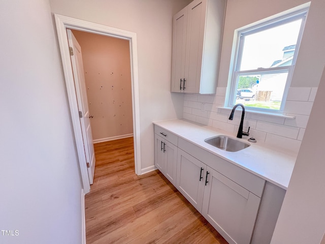 403 Duncan Creek Rd # 131, Lillington, NC 27546 - kitchen featuring a sink, decorative backsplash, light wood-style floors, baseboards, and light countertops