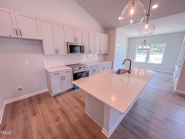 403 Duncan Creek Rd # 131, Lillington, NC 27546 - kitchen featuring appliances with stainless steel finishes, a sink, decorative backsplash, light countertops, and light wood-type flooring