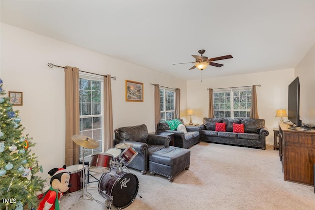 living room featuring light carpet, ceiling fan, and a healthy amount of sunlight