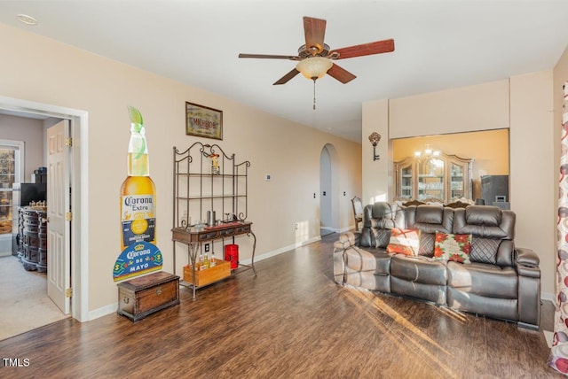 living room featuring ceiling fan and dark wood-type flooring