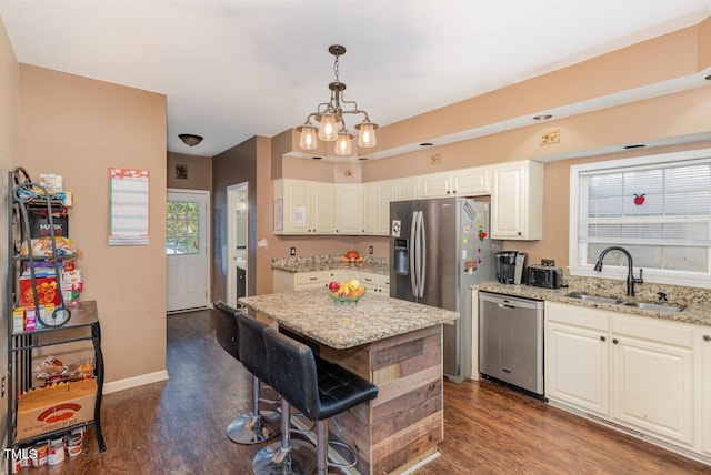 kitchen featuring white cabinetry, sink, light stone counters, dark hardwood / wood-style flooring, and appliances with stainless steel finishes