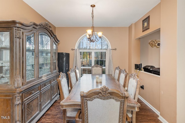 dining space with an inviting chandelier and dark wood-type flooring