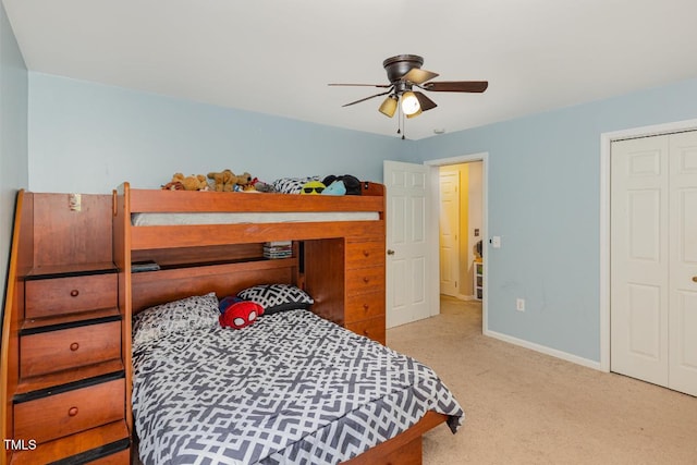 carpeted bedroom featuring ceiling fan and a closet