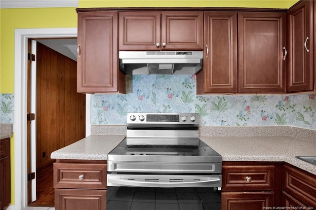 kitchen with electric range, decorative backsplash, and tile patterned floors