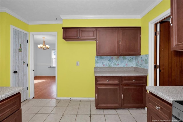 kitchen featuring light tile patterned flooring, ornamental molding, and a chandelier