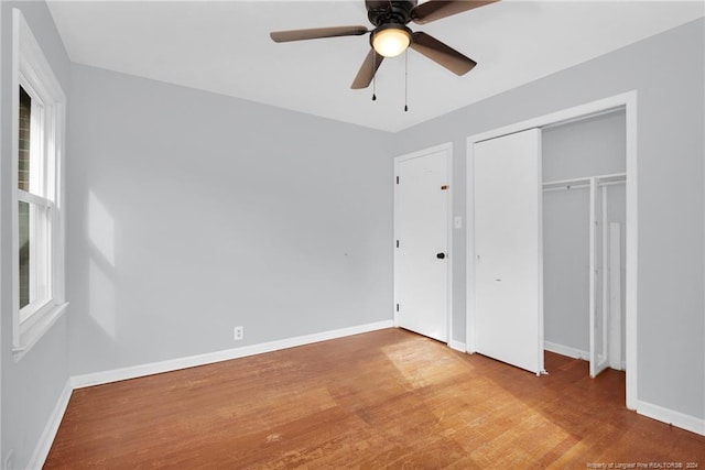 unfurnished bedroom with hardwood / wood-style flooring, ceiling fan, and a closet
