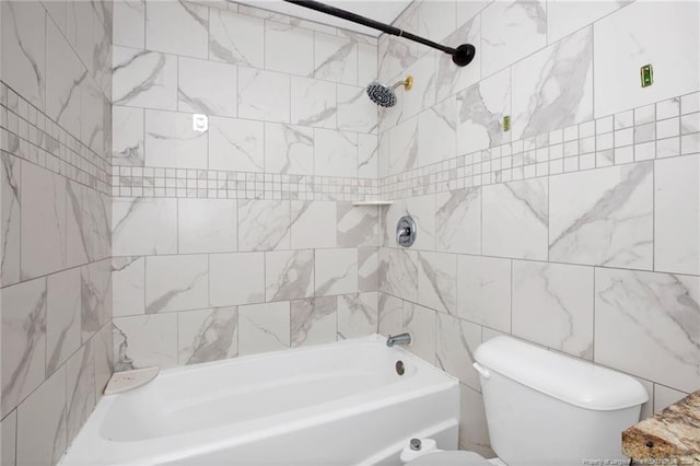 bathroom featuring tiled shower / bath combo, tile walls, and toilet
