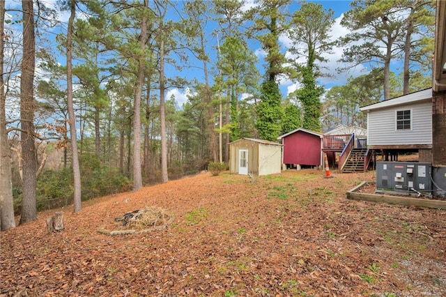 view of yard featuring central AC, a shed, and a wooden deck