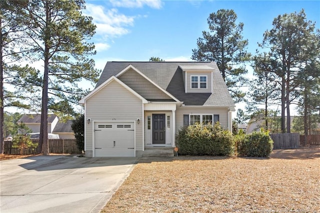 view of front facade featuring a garage, concrete driveway, and fence