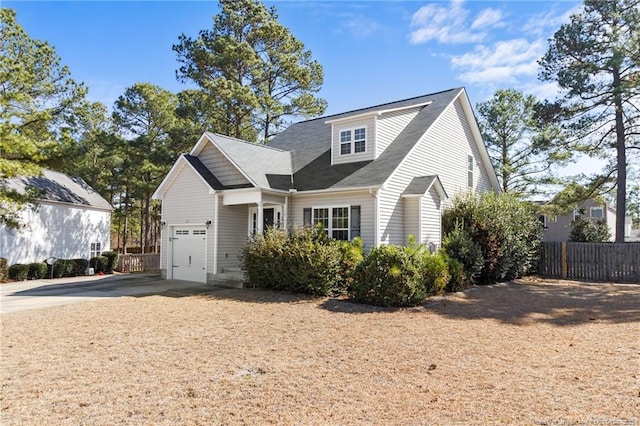 view of front of home with driveway, a garage, and fence