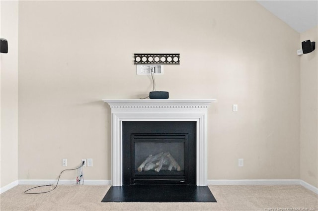 interior details with a fireplace with flush hearth, carpet, and baseboards