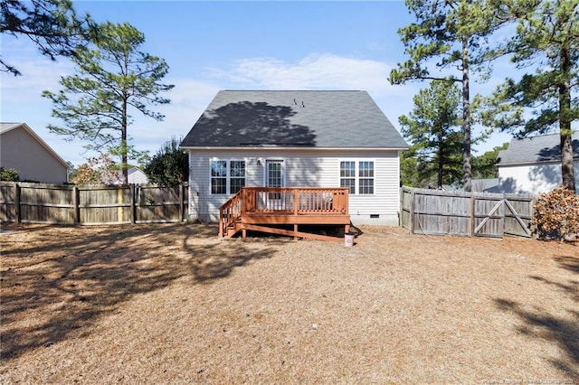 back of property with a deck, crawl space, a fenced backyard, and a gate