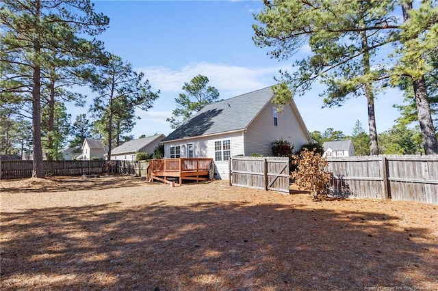 back of property featuring a fenced backyard and a deck