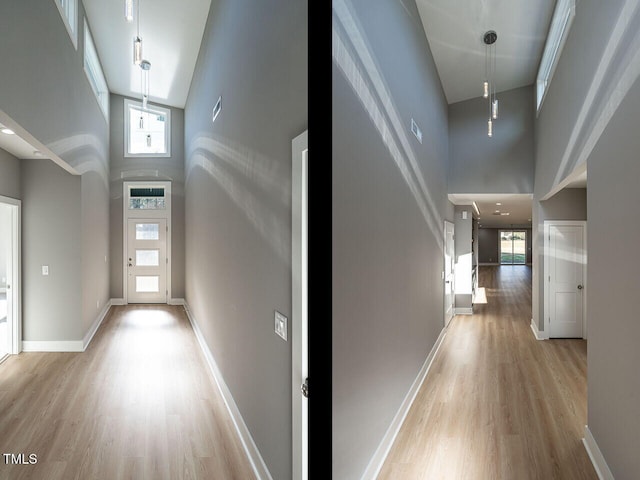 corridor with a towering ceiling, a healthy amount of sunlight, and light wood-type flooring