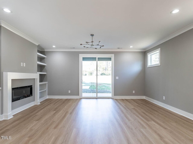 unfurnished living room with built in shelves, a healthy amount of sunlight, and ornamental molding