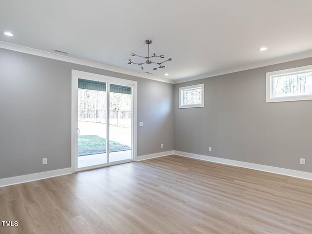 empty room with light hardwood / wood-style floors, crown molding, and a notable chandelier