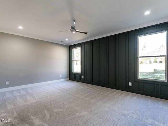 carpeted spare room with ceiling fan and ornamental molding