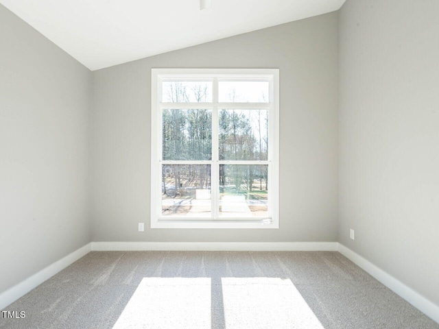 carpeted empty room with vaulted ceiling