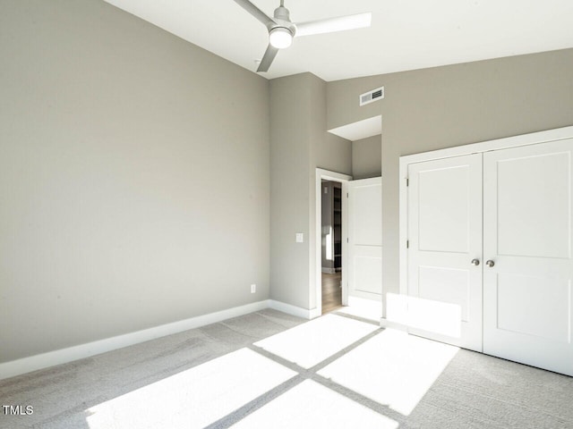 unfurnished bedroom featuring ceiling fan, lofted ceiling, light carpet, and a closet