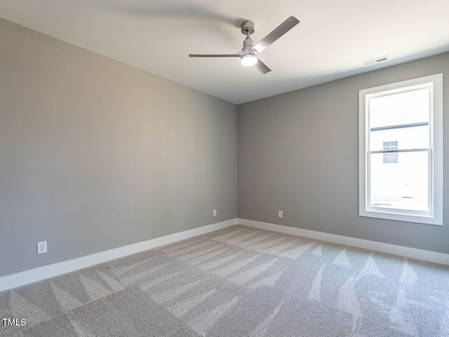 carpeted spare room with ceiling fan