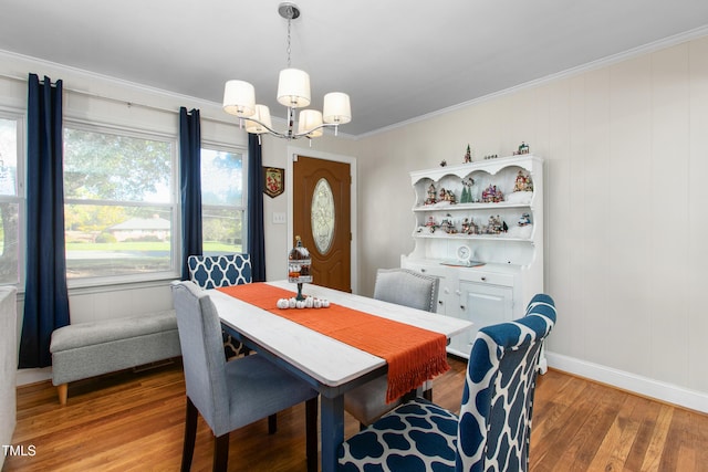 dining room with hardwood / wood-style flooring, crown molding, and a chandelier