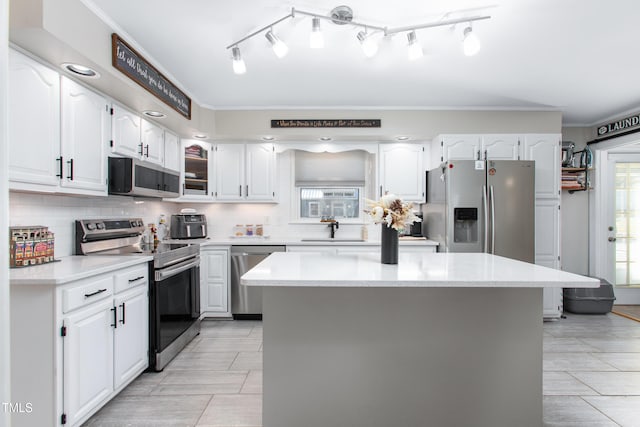 kitchen with white cabinetry, sink, a kitchen island, and appliances with stainless steel finishes