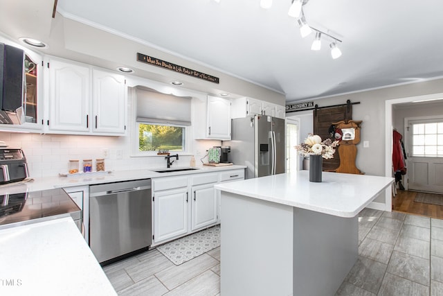 kitchen with a center island, sink, plenty of natural light, white cabinetry, and stainless steel appliances