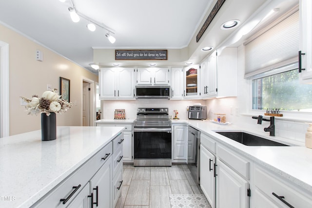 kitchen featuring white cabinets, backsplash, sink, and stainless steel appliances