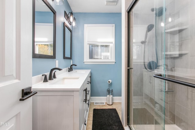 bathroom with tile patterned flooring, vanity, and walk in shower