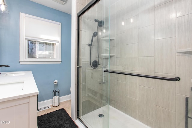 bathroom featuring tile patterned flooring, vanity, toilet, and an enclosed shower