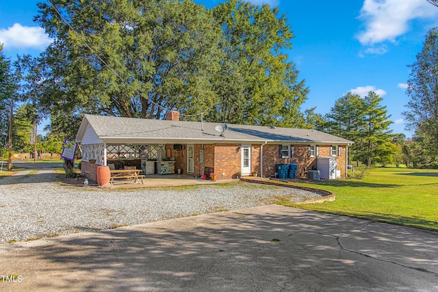 view of front of home featuring a patio, a front lawn, and central air condition unit