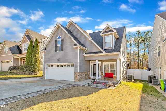 view of front of home featuring central air condition unit, a front lawn, and a garage