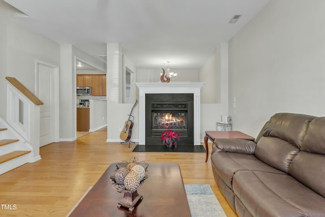 living room featuring light hardwood / wood-style flooring and an inviting chandelier