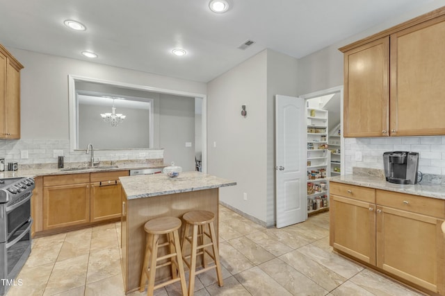 kitchen featuring decorative backsplash, a kitchen island, stainless steel range oven, and sink