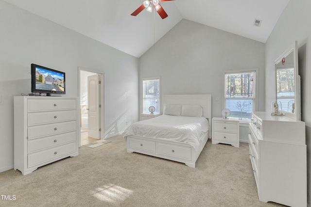 carpeted bedroom featuring ceiling fan, high vaulted ceiling, and ensuite bath