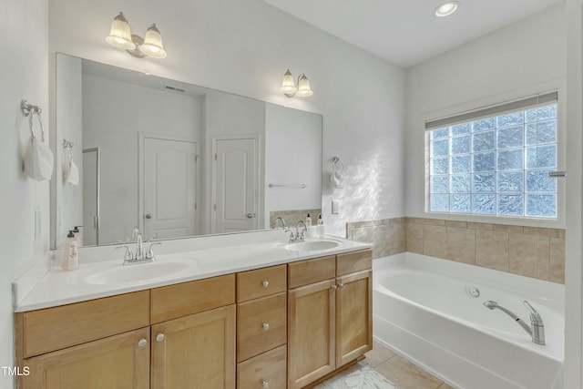 bathroom featuring tile patterned flooring, vanity, and a tub