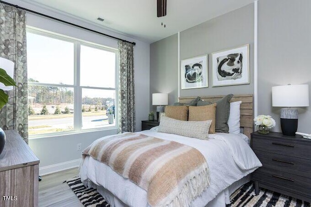 bedroom with multiple windows, ceiling fan, and light wood-type flooring