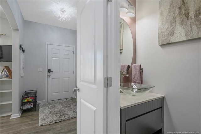 bathroom featuring vanity, wood-type flooring, and a chandelier