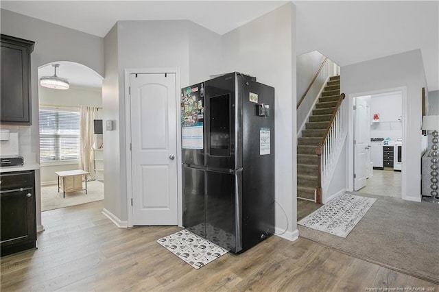 kitchen with black fridge and light hardwood / wood-style flooring