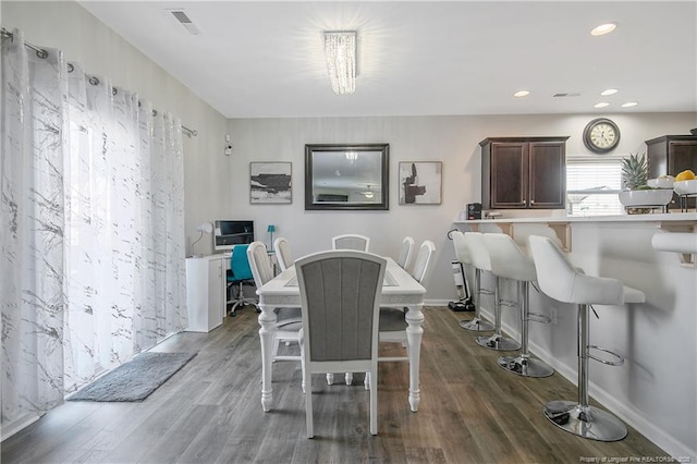 dining room with dark hardwood / wood-style floors and a notable chandelier