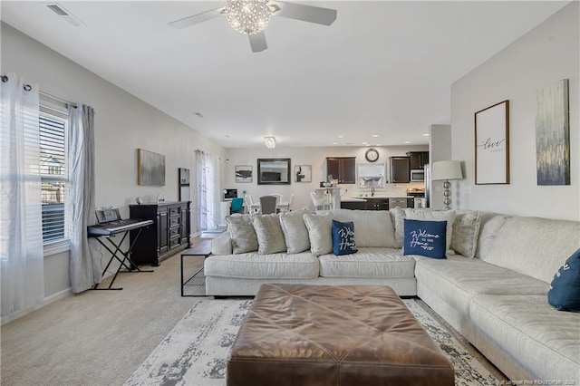 living room featuring ceiling fan and light colored carpet