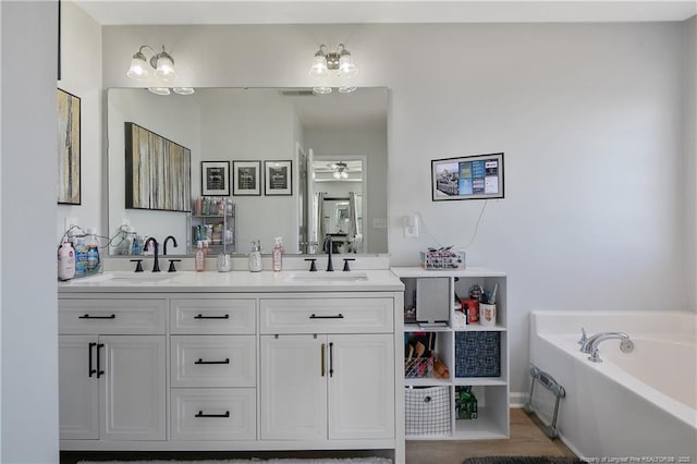 bathroom featuring a tub, ceiling fan, and vanity