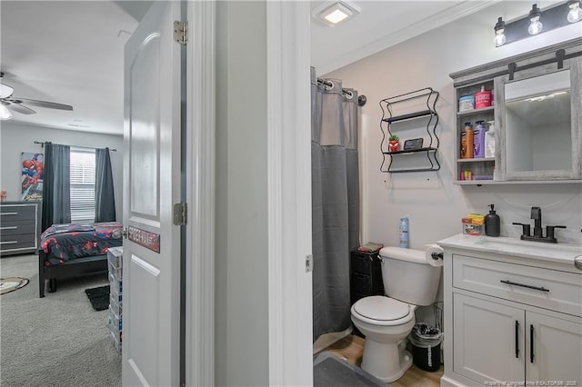 bathroom with curtained shower, ceiling fan, vanity, and toilet