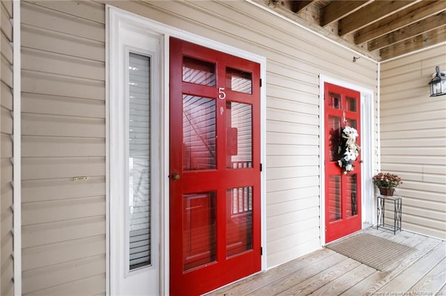 view of exterior entry featuring covered porch