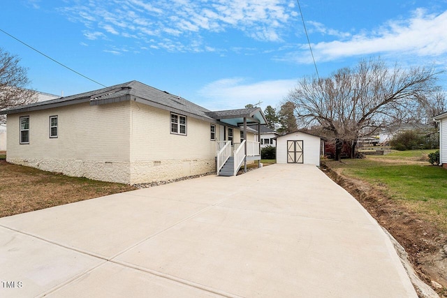 view of home's exterior featuring a lawn and a storage unit