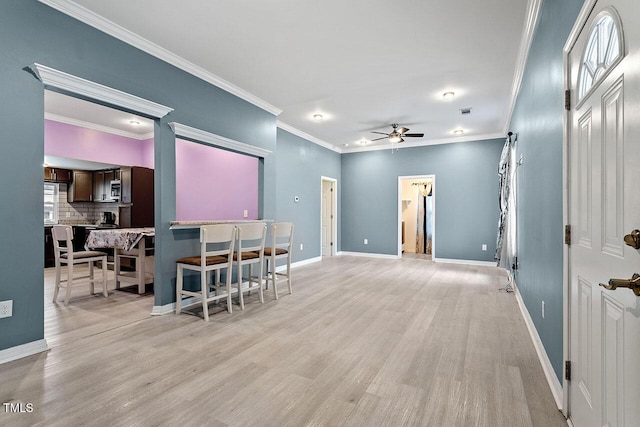 interior space with decorative backsplash, dark brown cabinetry, light hardwood / wood-style flooring, and ceiling fan