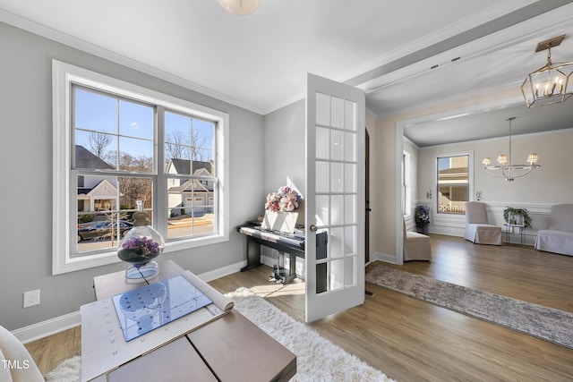 office space with a chandelier, french doors, light wood-type flooring, and crown molding