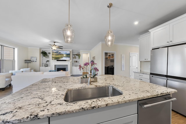 kitchen with white cabinets, ceiling fan, ornamental molding, decorative light fixtures, and stainless steel appliances