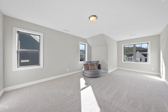 bonus room with light carpet and vaulted ceiling